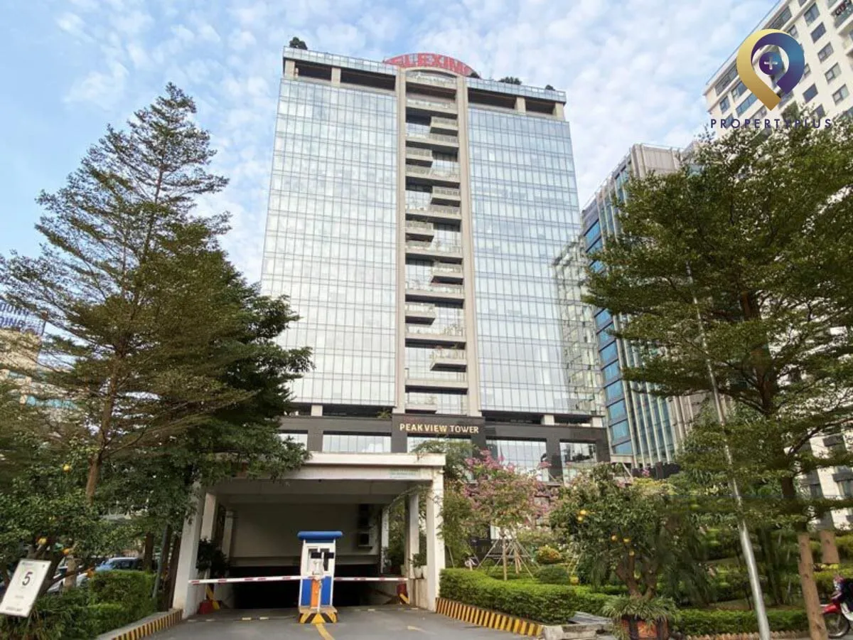 Tòa nhà Peakview Tower nhìn từ phía trước với không gian xanh và lối vào bãi xe